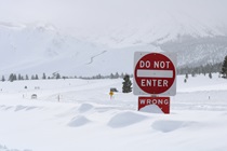Snow covers part of a Do Not Enter sign on U.S. 395 near Mammoth Lakes in January 2023.
