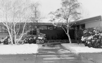 A black and white photo showing a snowy main entrance to the District Office building. (Undated)