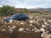 A vehicle is stuck in mud and rocks following flash floods on State Route 202 on July 19, 2015.
