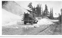 An undated black and white image of a snowblower and snowplow working together to clear snow from the road.
