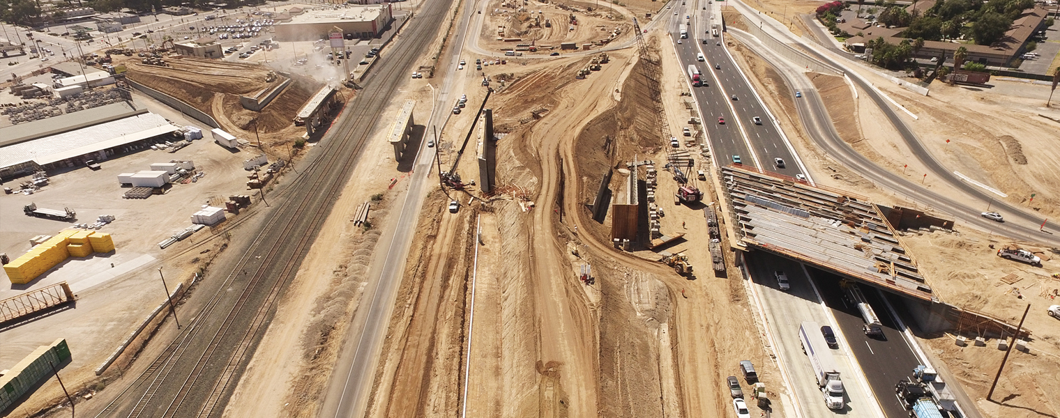 Aerial image of the early phase of construction, showing heavy equipment and a portion of a new overcross