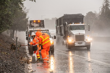 Two Maintenance crew workers tidy up along northbound State Route 99, just north of 12th Street in Sacramento, during the storms. (Headquarters photograph by Scott Lorenzo)