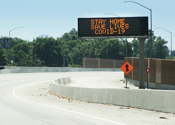 Photo of a changeable message sign reading, "Stay Home, Save Lives, COVID-19."